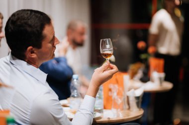 Vinnitsa, Ukrayna - 21 Eylül 2024: Bir etkinlikte kaliteli viski tatma deneyiminin tadını çıkaran adam. Yüksek kalite fotoğraf