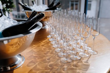 Masada buz kovalarında soğutulmuş şampanya şişeleriyle hazırlanmış zarif şampanya kadehleri. Yüksek kalite fotoğraf