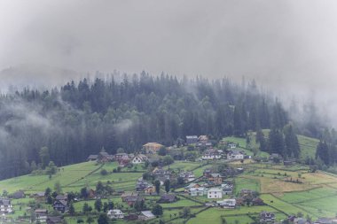 Vorokhta köyünde puslu bir sabah. Karpat tepeleri ve sis kaplı dağlar manzaralı. Yüksek kalite fotoğraf