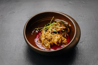 Yavaş pişirilmiş et güveci soslu ve taze otlarla servis edilir. Stok yiyecek fotoğrafçılığı için ideal. Yüksek kalite fotoğraf