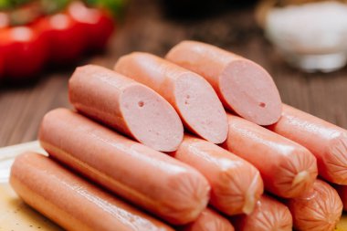 Tabakta bir yığın sosis, barbekü, ızgara ya da hızlı yemek için ideal mutfak ortamında sergileniyor. Yüksek kalite fotoğraf