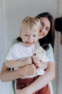 Mother and son smiling, sharing a joyful moment indoors, creating a warm family connection. High quality photo clipart