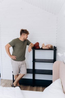 Baba ve oğul minimalist bir evde birlikte vakit geçirip eğlenceli bir an yaratıyorlar. Yüksek kalite fotoğraf