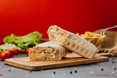 Freshly grilled chicken wrap cut in half, revealing creamy filling. Perfect fast-food snack. High quality photo clipart