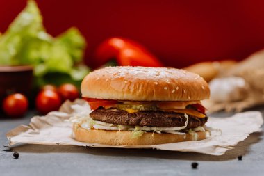 Taze sebzeli sulu çizburger ve susamlı ekmek üzerine erimiş peynir, fast-food severler. Yüksek kalite fotoğraf