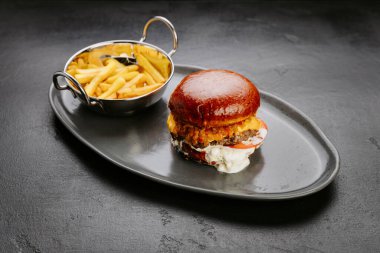 Siyah tabakta kızarmış patatesli sulu çizburger fast food aşıkları ve konfor arayanlar için yemek. Yüksek kalite fotoğraf