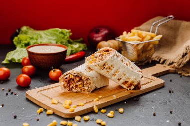 İçinde mısır dolgulu, kesilmiş ve stil verilmiş sulu barbekü soslu tavuk dürümü. Fast-food aşıkları için ideal. Yüksek kalite fotoğraf