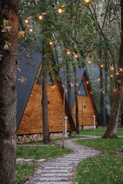 Ormandaki sıcak ışıklarla çevrili bir kulübede doğayla çevrili rahat bir inzivaya çekilmeyi öneriyorlar. Yüksek kalite fotoğraf