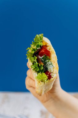 Marul, domates, otlar ve sosla doldurulmuş taze pita dürümü sağlıklı yemek ve atıştırmalıklar için idealdir. Yüksek kalite fotoğraf