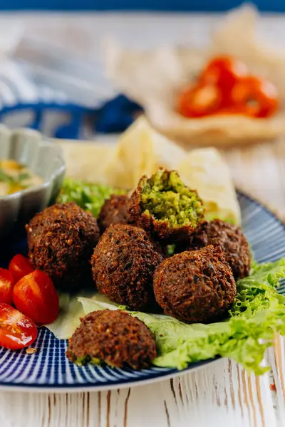 Humuslu falafel tabağı, kiraz domatesleri, marul ve pita cipsi, mükemmel Akdeniz yemeği. Yüksek kalite fotoğraf