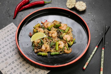 Kızarmış tavuk, sebzeli ve cam erişteli sağlıklı bir yemek için susam tohumlarıyla süslenmiş. Yüksek kalite fotoğraf