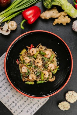 Kızarmış tavuk, sebzeli ve cam erişteli sağlıklı bir yemek için susam tohumlarıyla süslenmiş. Yüksek kalite fotoğraf