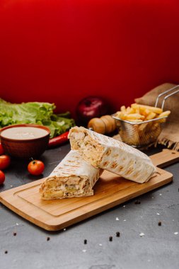 Taze ızgara tavuk dürümü, kremalı dolguyu ortaya çıkarıyor. Mükemmel fast-food atıştırmalığı. Yüksek kalite fotoğraf