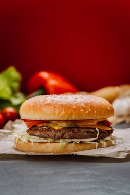 Taze sebzeli sulu çizburger ve susamlı ekmek üzerine erimiş peynir, fast-food severler. Yüksek kalite fotoğraf