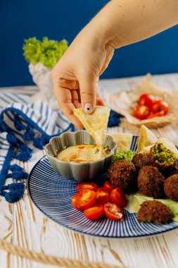 Pide ekmeğini kremalı humusa batırmak. Mükemmel bir Orta Doğu atıştırma deneyimi. Yüksek kalite fotoğraf