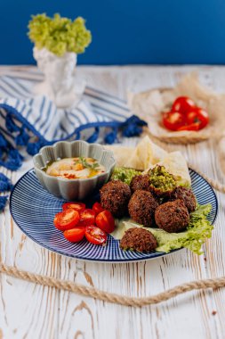 Humuslu falafel tabağı, kiraz domatesleri, marul ve pita cipsi, mükemmel Akdeniz yemeği. Yüksek kalite fotoğraf