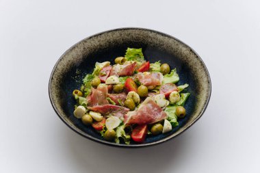 Prosciutto, mozzarella, domates, zeytin ve yeşillik serpiştirilmiş Akdeniz salatası. Yüksek kalite fotoğraf