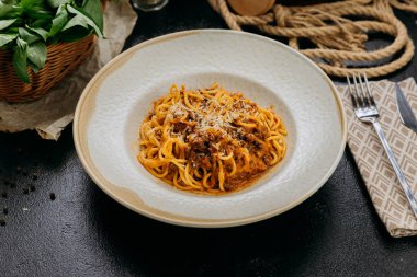 Parmesan soslu klasik spagetti bolonez. Zarif bir ortamda servis ediliyor. Yüksek kalite fotoğraf