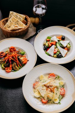 Üçlü gurme salata, ızgara sebze ve Sezar. Ekmek ve kırmızı şarapla eşleştirilmiş. Yüksek kalite fotoğraf