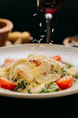 Izgara tavuk, parmesan peynirli, kiraz domatesli ve haşlanmış bıldırcın yumurtalı zarif Sezar salatası. Yüksek kalite fotoğraf