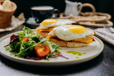 Kızarmış yumurtalı tost, çedar, yeşillik ve latte ile servis edilen bir salata ile gurme kahvaltısı. Yüksek kalite fotoğraf