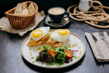 Kızarmış yumurtalı tost, çedar, yeşillik ve latte ile servis edilen bir salata ile gurme kahvaltısı. Yüksek kalite fotoğraf