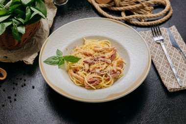 Parmesan peynirli, fesleğenli ve çıtır pastırmalı klasik carbonara makarnası. Yüksek kalite fotoğraf