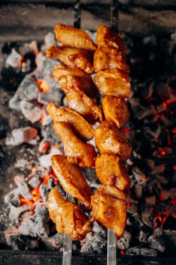 Juicy marinated chicken wings grilled over hot charcoal for the ultimate barbecue experience. High quality photo clipart