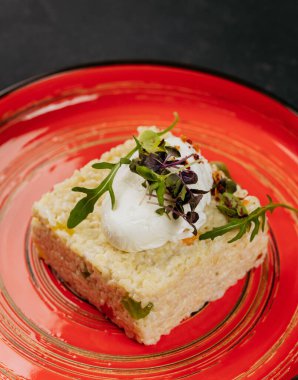 Kavrulmuş yumurta ve canlı kırmızı bir tabakta mikro yeşillik ile kaplanmış zarif kinoa tabağı. Yüksek kalite fotoğraf