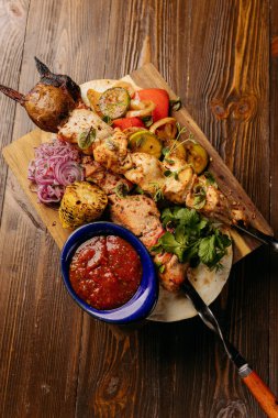 Baharatlı sos ile ahşap bir tahtanın üzerinde servis edilen ızgara şiş manzarası. Yüksek kalite fotoğraf