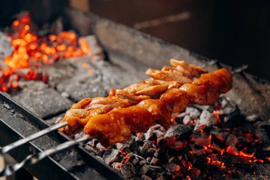 Sıcak kömürlerin üzerinde ızgara yapılan leziz et, açık hava barbeküsünün özünü yakalıyor. Yüksek kalite fotoğraf