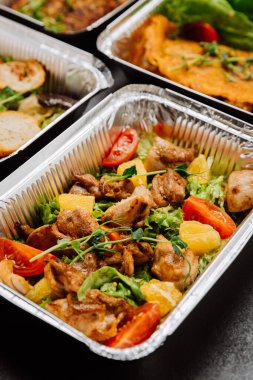 Taze ve renkli domates ve portakallı tavuk salatası, kabın içinde servis ediliyor, sağlıklı servis ediliyor. Yüksek kalite fotoğraf