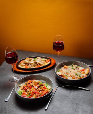 Kırmızı şarap bardakları ve gurme yemekleri olan şık bir akşam yemeği sofistike bir akşam yemeği için mükemmel. Yüksek kalite fotoğraf