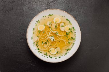 Haşlanmış yumurta dilimleri, şifalı otlar ve tavuk kübü, rahatlatıcı ve hafif bir yemek ile berrak erişte çorbası. Yüksek kalite fotoğraf