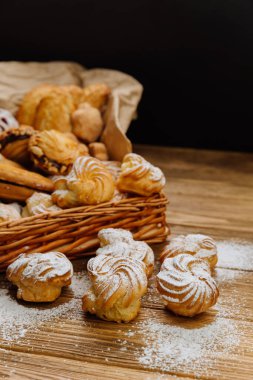 Kırsal bir ahşap masada toz şekerle kaplanmış taze kremalı hamur tatlısı. Yüksek kalite fotoğraf