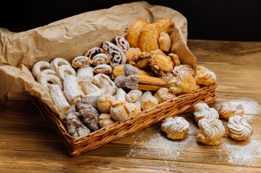 Köy sepetinde taze hamur işleri ve kurabiyelerden oluşan lezzetli bir karışım, toz şekerle kaplanmış. Yüksek kalite fotoğraf