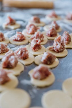 Çiğ hamur köfteleri, taze hazırlanmış hamur çemberleri, üzerine de baharatlı et dolgusu. Yüksek kalite fotoğraf