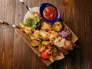 Baharatlı sos ile ahşap bir tahtanın üzerinde servis edilen ızgara şiş manzarası. Yüksek kalite fotoğraf