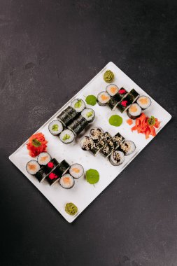 Somon, salatalık, susam, wasabi, zencefil ve yumurtayla süslenmiş çeşit çeşit suşi ruloları. Yüksek kalite fotoğraf