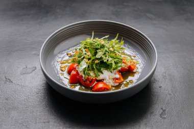 Taze roka ve kiraz domatesli burrata salatası, fındık ve gurme dokunuşu için zeytinyağı. Yüksek kalite fotoğraf