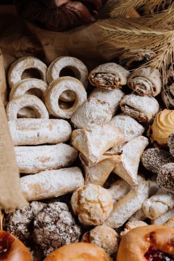 Pudra şekeri ve dekoratif detaylarla çeşitli geleneksel hamur işleri, tatlı severler için mükemmel. Yüksek kalite fotoğraf