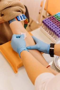 Tıbbi bir klinikte kan tahlilinden sonra hastalara pamuk uygulayan bir sağlık uzmanı. Yüksek kalite fotoğraf