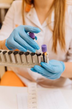 Lab technician handling blood samples with precision and care for medical analysis in a clinical lab. High quality photo clipart