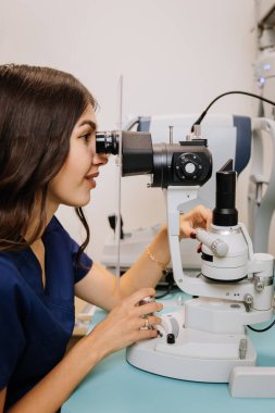 Tıbbi bir klinikte detaylı bir göz muayenesi için kesik lamba mikroskobu kullanan bir optometrist. Yüksek kalite fotoğraf