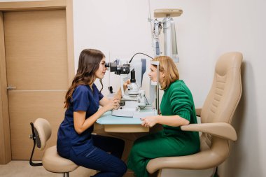 Modern bir klinikte ileri seviye lamba ekipmanı kullanan bir optometristin profesyonel göz muayenesi. Yüksek kalite fotoğraf
