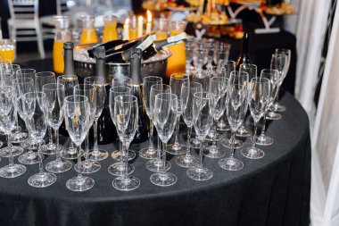 Luxury event setup with champagne bottles, flutes, and orange juice on a banquet table. High quality photo clipart