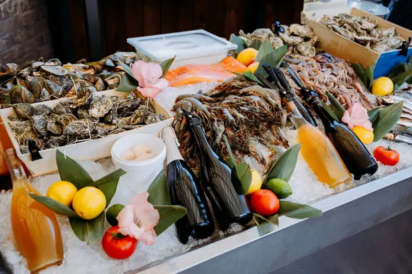 Bir gurme yiyecek pazarında buzlu taze deniz ürünleri, istiridye, karides ve içeceklerle birlikte. Yüksek kalite fotoğraf