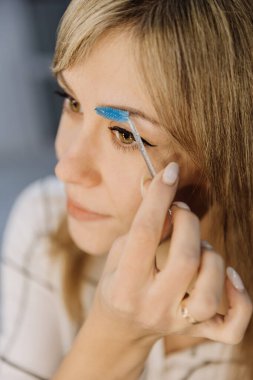 Kusursuz güzellik ve tanımlanmış kaşlar için mavi ürkütücü fırçayla kaşlarını tımar et. Yüksek kalite fotoğraf