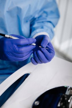 Diş hekimi, dişçi prosedürü hazırlıkları sırasında steril eldiven üzerinde hassas bir alet kullanıyor. Yüksek kalite fotoğraf