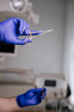 Diş ipi tutan bir diş hekimi ve klinik ortamda ağız hijyeni tanıtımı için aletler. Yüksek kalite fotoğraf